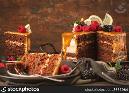 Delicious semi-naked chocolate cake with caramel topping and decorated with blackberries and raspberries. Dark background