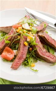 delicious slices of meat with rocket salad and toamtoes