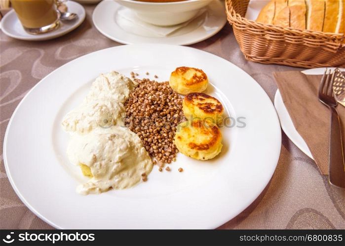 Delicious Slovenian food without meat, consisting of boiled potato dumplings with onions and cream sauce, baked dodole and Buckwheat porridge.