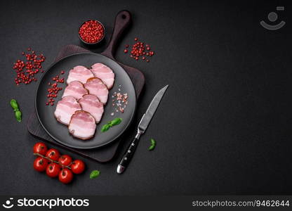 Delicious smoked bacon with salt, spices and herbs on a dark concrete background