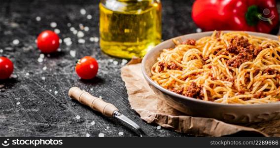 Delicious spaghetti bolognese in a bowl with cherry tomatoes. On a black background. High quality photo. Delicious spaghetti bolognese in a bowl with cherry tomatoes.
