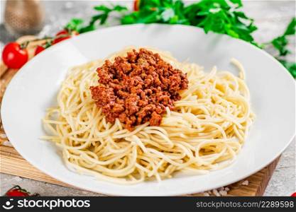Delicious spaghetti bolognese with parsley. On a gray background. High quality photo. Delicious spaghetti bolognese with parsley.