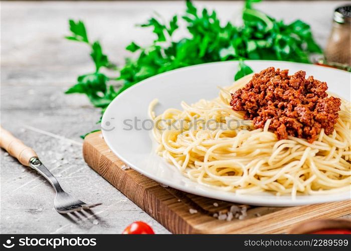 Delicious spaghetti bolognese with parsley. On a gray background. High quality photo. Delicious spaghetti bolognese with parsley.
