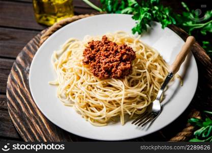 Delicious spaghetti bolognese with parsley. On a wooden background. High quality photo. Delicious spaghetti bolognese with parsley.