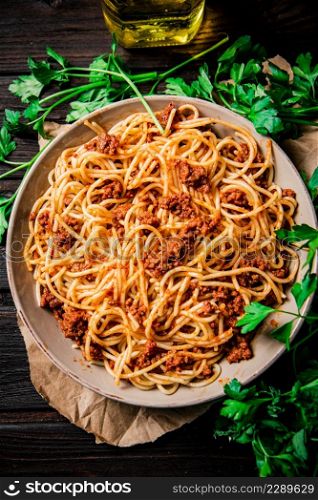Delicious spaghetti bolognese with parsley. On a wooden background. High quality photo. Delicious spaghetti bolognese with parsley.