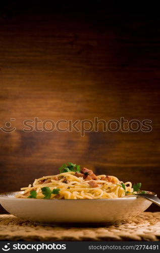 Delicious spaghetti with bacon and egg called alla carbonara on wooden table