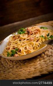 Delicious spaghetti with bacon and egg called alla carbonara on wooden table