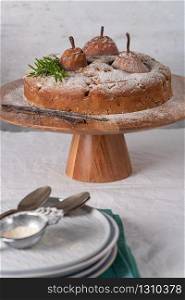 Delicious spice cake with pear, ginger and cinnamon on a white kitchen counter.