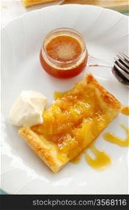Delicious spiced pineapple galette served with cream and pineapple syrup.
