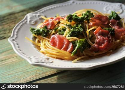 Delicious spicy linguine pasta with fried cabbage kale, bacon, garlic and parmesan on a white plate . Top view .. Delicious spicy linguine pasta with fried cabbage kale, bacon, garlic and parmesan on a white plate . Top view