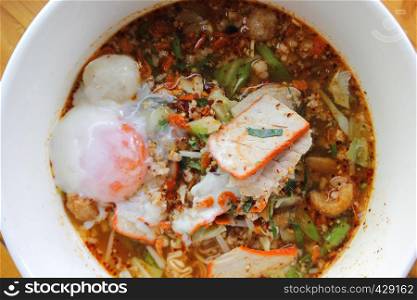 delicious spicy red pork noodles soup with soft-boiled egg