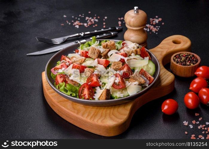 Delicious spring fresh vegetable salad with cherry tomatoes, cucumber, breadcrumbs and parmesan cheese on a dark concrete background. Delicious spring fresh vegetable salad with cherry tomatoes, cucumber, breadcrumbs and parmesan cheese