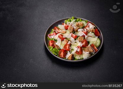 Delicious spring fresh vegetable salad with cherry tomatoes, cucumber, breadcrumbs and parmesan cheese on a dark concrete background. Delicious spring fresh vegetable salad with cherry tomatoes, cucumber, breadcrumbs and parmesan cheese