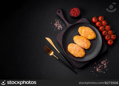 Delicious steam cutlets with carrots, cheese, salt and spices on a dark concrete background