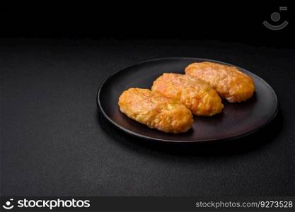 Delicious steam cutlets with carrots, cheese, salt and spices on a dark concrete background