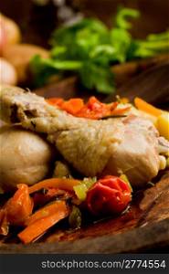 delicious stewed chicken with vegetables inside rustical wooden plate