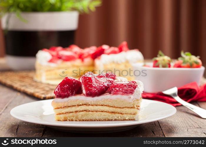 delicious strawberry cake with cream on wooden table