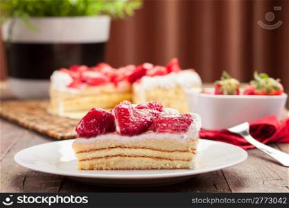 delicious strawberry cake with cream on wooden table