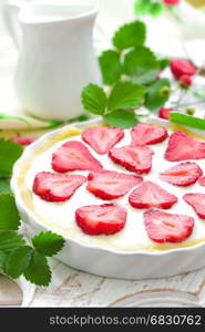 Delicious strawberry tart or cheesecake with fresh berries and cream cheese, closeup on white wooden rustic background