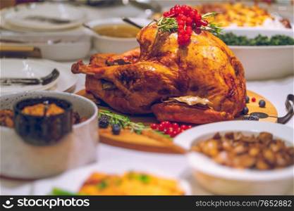 Delicious Stuffed Turkey in the Center of the Table. Tasty Meal for Thanksgiving Day. Traditional American Family Holiday. Festive Dinner at Home.
