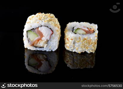 Delicious sushi rolls on black background