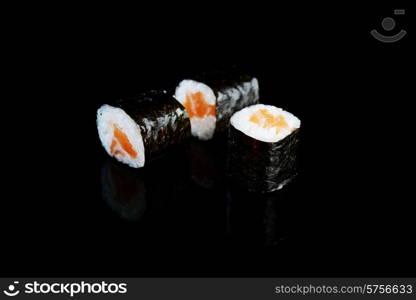 Delicious sushi rolls on black background