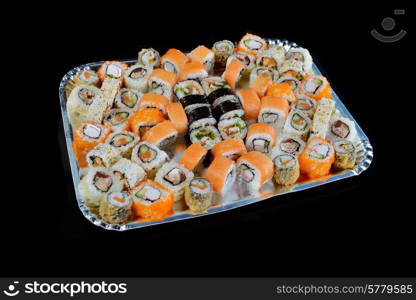 Delicious sushi rolls on black background