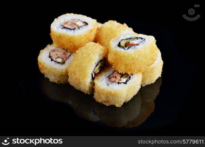 Delicious sushi rolls on black background