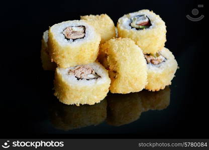 Delicious sushi rolls on black background