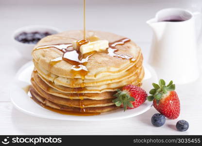 Delicious sweet American pancakes on a plate with fresh fruits. Delicious sweet American pancakes on a plate with fresh fruits and addons.