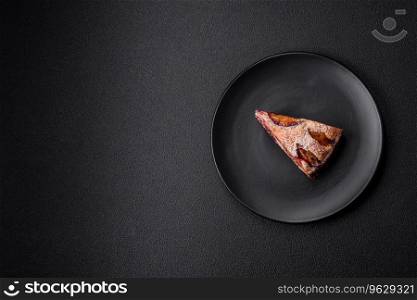 Delicious sweet aromatic homemade pie with ripe plums on a dark concrete background