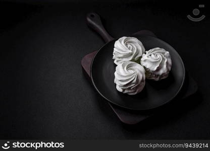 Delicious sweet colored marshmallow on a dark concrete background. Healthy sweets for the dinner table