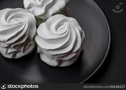 Delicious sweet colored marshmallow on a dark concrete background. Healthy sweets for the dinner table