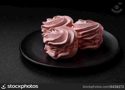 Delicious sweet colored marshmallow on a dark concrete background. Healthy sweets for the dinner table