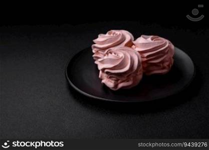 Delicious sweet colored marshmallow on a dark concrete background. Healthy sweets for the dinner table