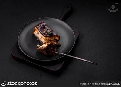 Delicious sweet dessert cheesecake with candied fruits in chocolate on a dark concrete background