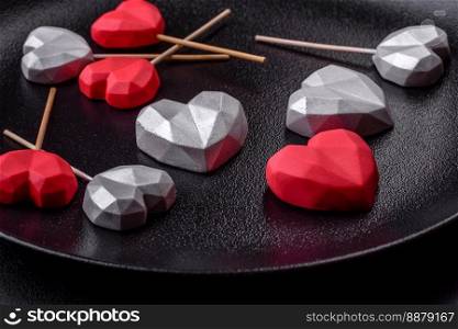 Delicious sweet heart shaped chocolate candies on a dark concrete background. Valentines day celebration