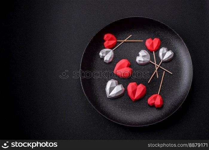 Delicious sweet heart shaped chocolate candies on a dark concrete background. Valentines day celebration