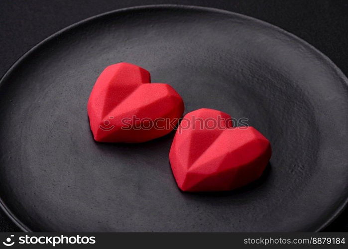 Delicious sweet heart shaped chocolate candies on a dark concrete background. Valentines day celebration