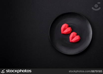 Delicious sweet heart shaped chocolate candies on a dark concrete background. Valentines day celebration