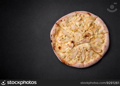 Delicious sweet pizza with pear, dorblu cheese and nuts on a dark concrete background