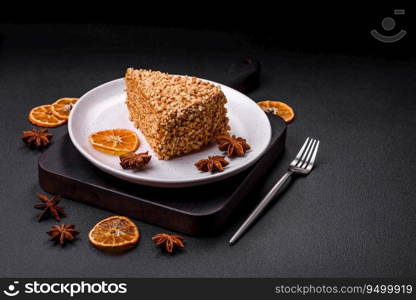 Delicious sweet puff waffle cake with cream and nuts cut into pieces on a textured concrete background