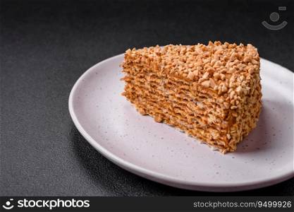 Delicious sweet puff waffle cake with cream and nuts cut into pieces on a textured concrete background