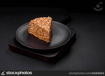 Delicious sweet puff waffle cake with cream and nuts cut into pieces on a textured concrete background