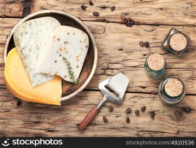 Delicious Swiss cheese. Three varieties of cheese with pine nuts on a retro wooden background