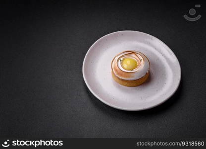 Delicious tart with citrus filling and walnut cream on a textured concrete background