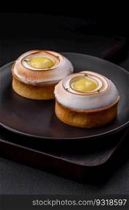 Delicious tart with citrus filling and walnut cream on a textured concrete background