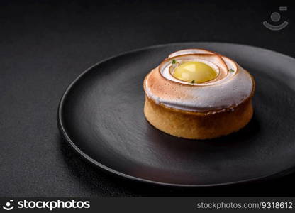 Delicious tart with citrus filling and walnut cream on a textured concrete background