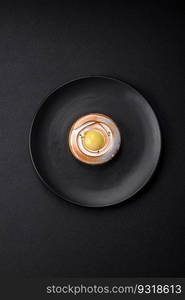 Delicious tart with citrus filling and walnut cream on a textured concrete background