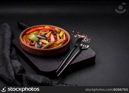 Delicious vegetables steamed peppers, asparagus beans and potatoes sliced with soy sauce on a dark concrete background